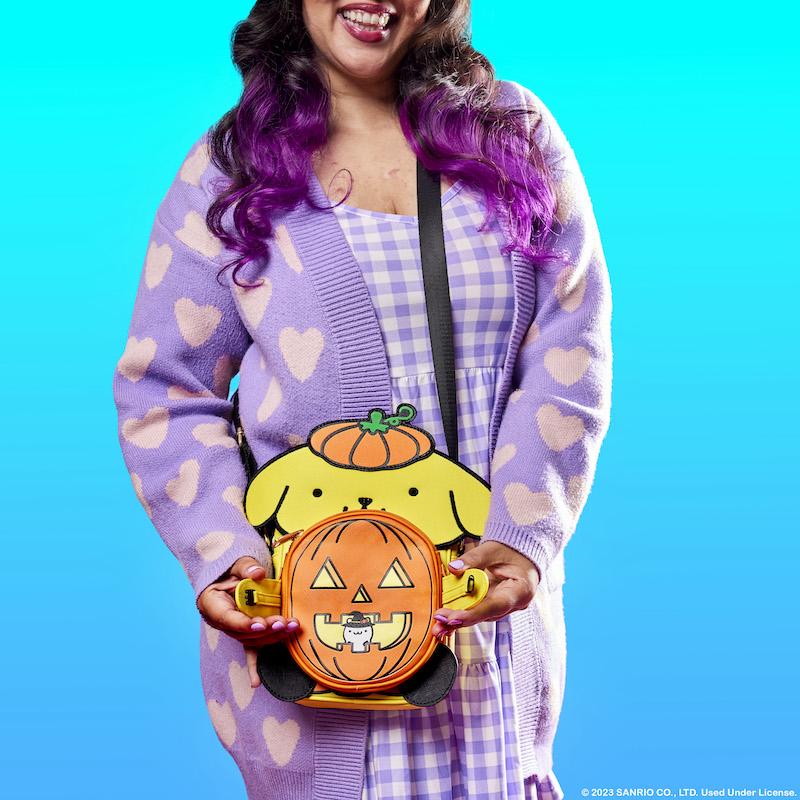 Woman wearing purple against a blue background wearing the Pompompurin Crossbuddies bag